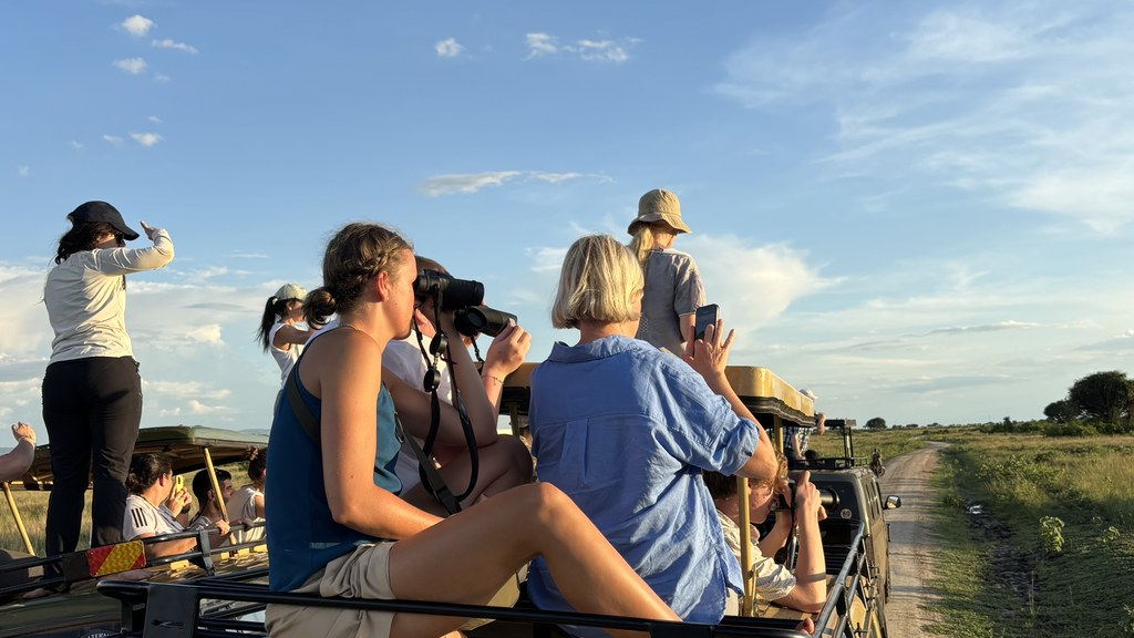 Guests on safari vehicle roof hatch during game drive