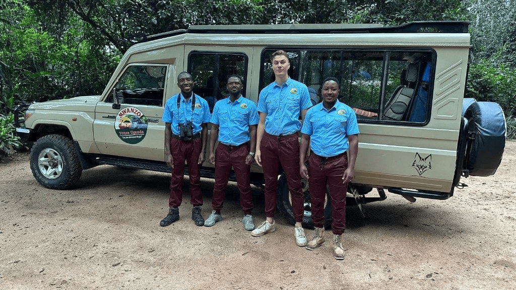 Mwanzo Tours safari guides in uniform beside a branded Land Cruiser in Uganda